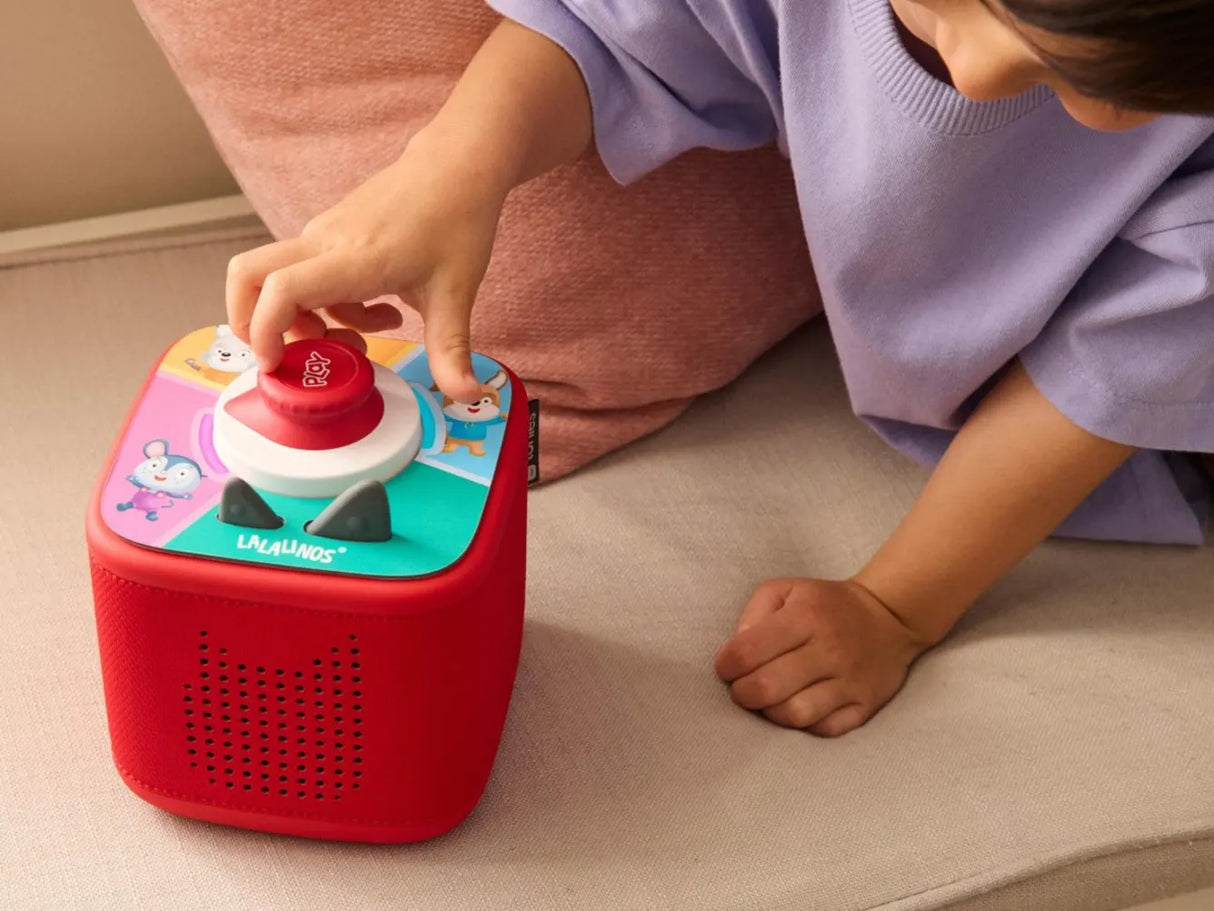 Child playing with a colorful toy box on a couch