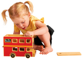 Child playing with a wooden toy bus on a white background