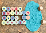 Close-up of engraved alphabet stamping stones showing letter details