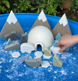 Playset with igloo and mountain shapes on a blue surface with snowflake pattern